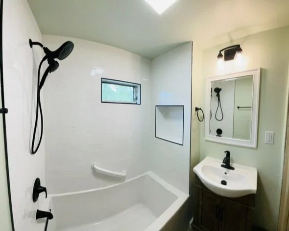 Bathroom with a tub and shower combination and matte black fixtures