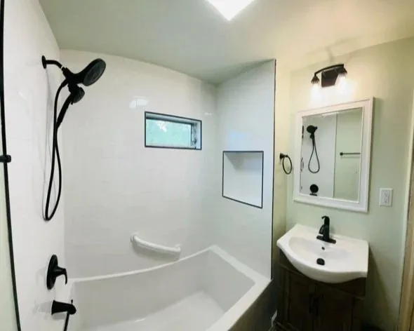 Bathroom with a tub and shower combination and matte black fixtures