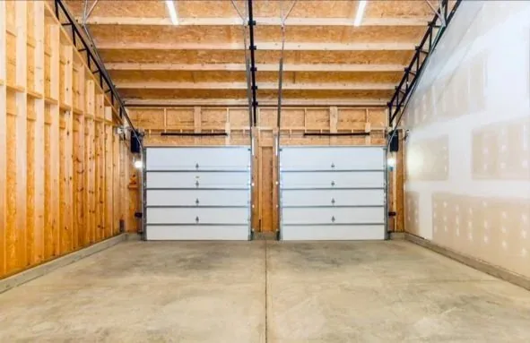 Interior of a finished detached garage with wood-lined walls and two bays